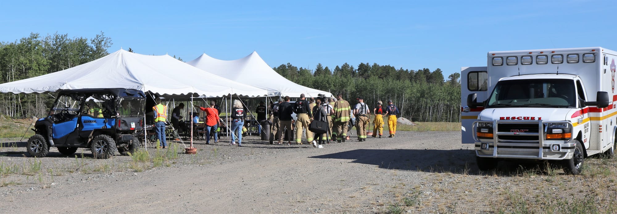 Volunteers gather under tents for an emergency preparedness drill.