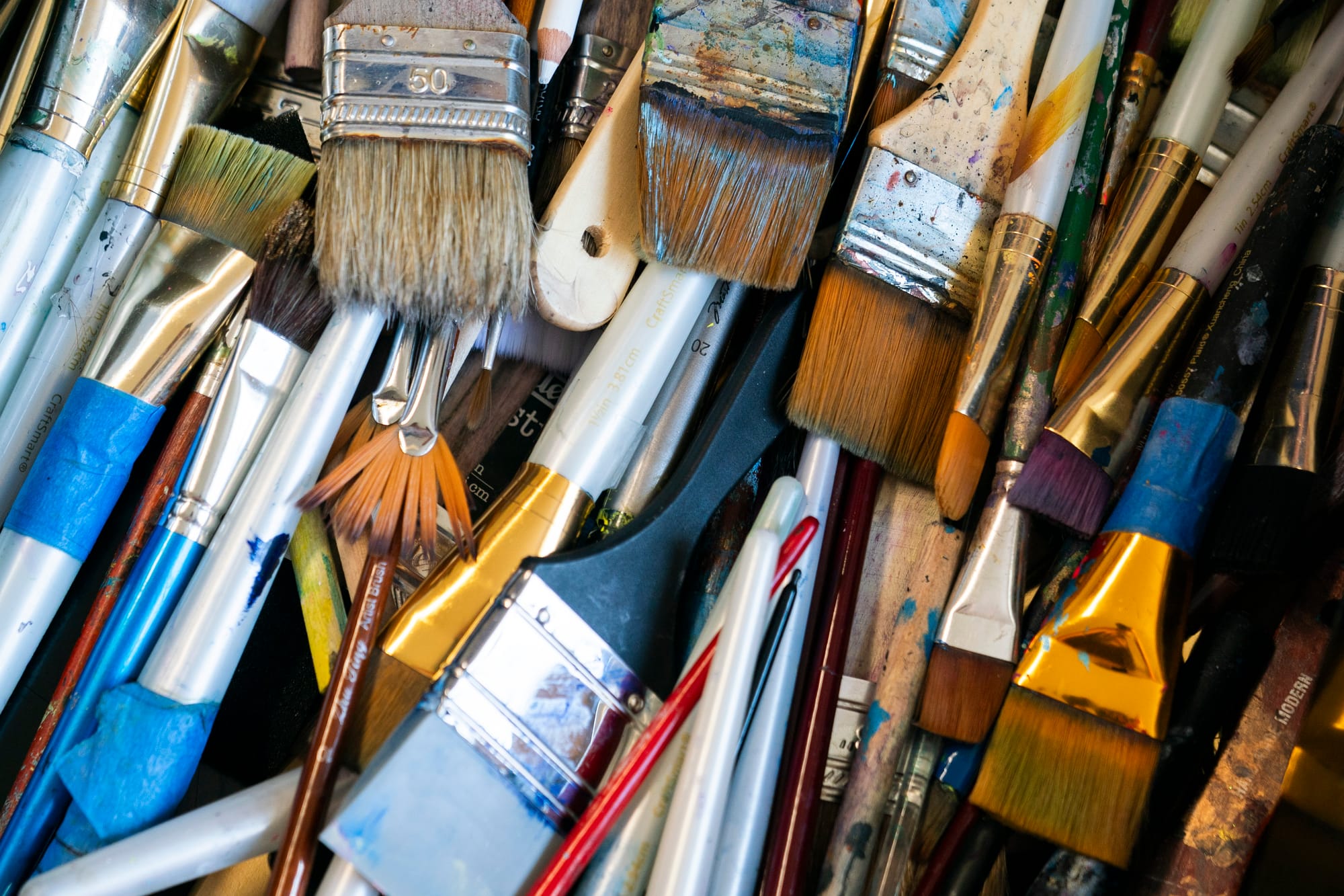 A close-up shot of paint brushes in a drawer at an artist's studio. 