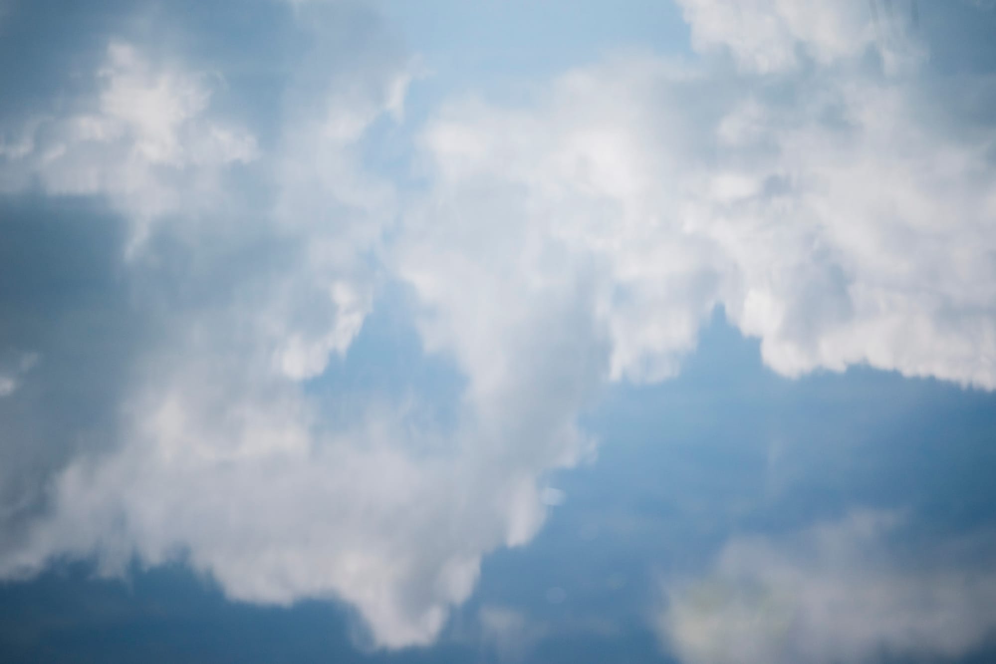 Fluffy white clouds are seen against a blue sky. 