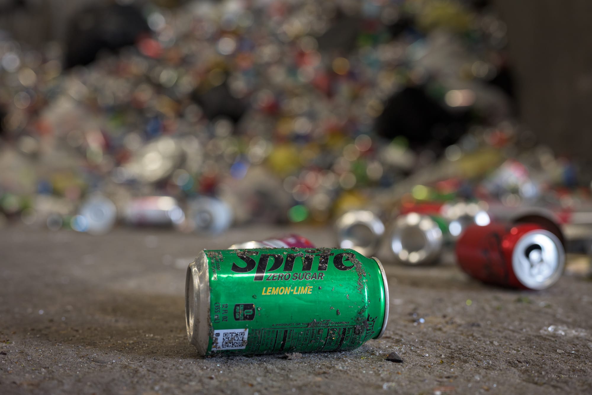 A can of Sprite sits on the floor of a recycling center.