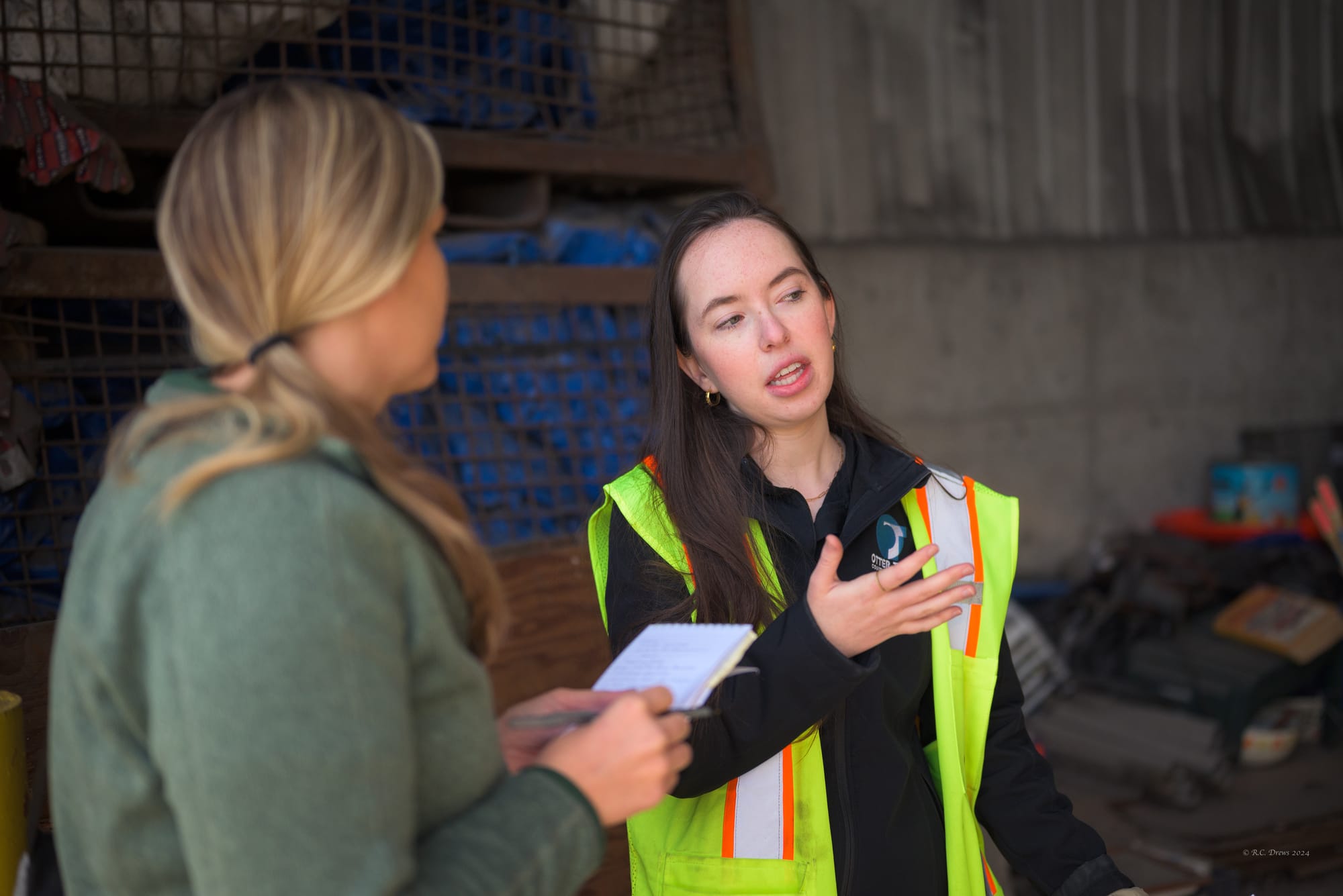 A woman explains how recycling at a recycling facility is sorted during a tour.