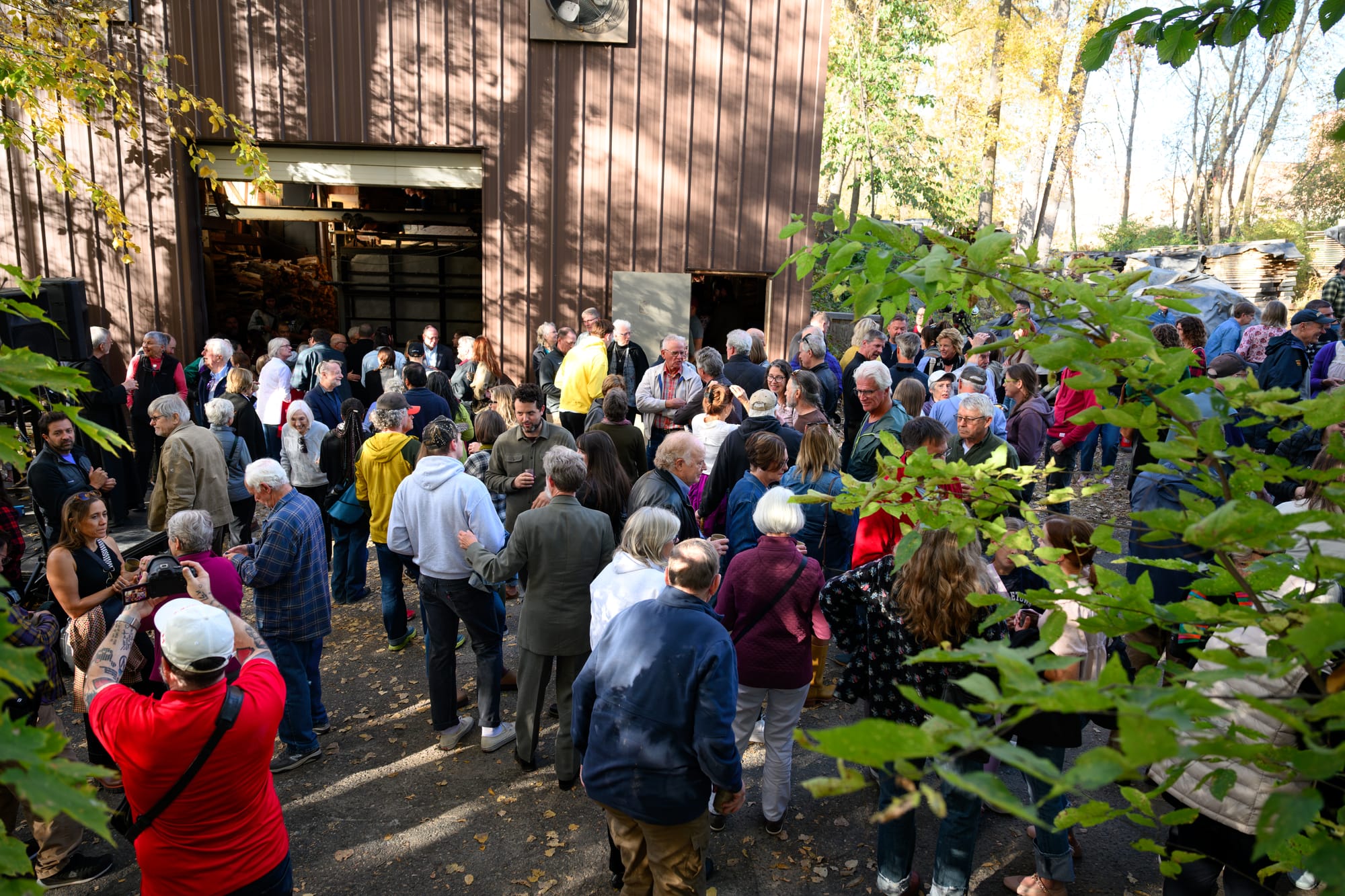 People gather outside of a building after a kiln lighting ceremony. 