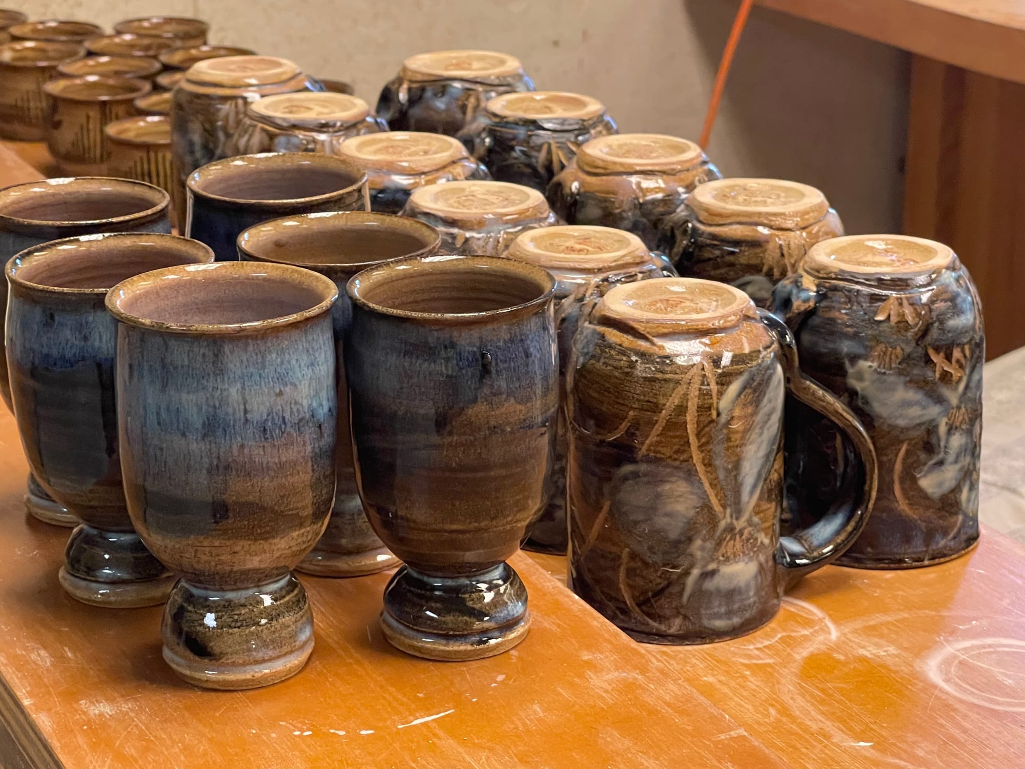 Mugs and glasses are seen in The Saint John's Pottery studio in Collegeville, Minn., in 2022. The artists create glazes from natural materials.