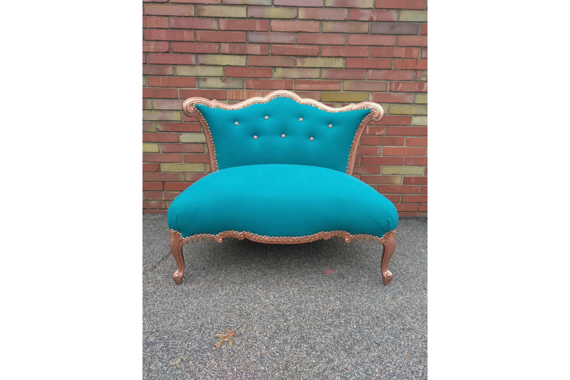 A teal colored settee that has been reupholstered.