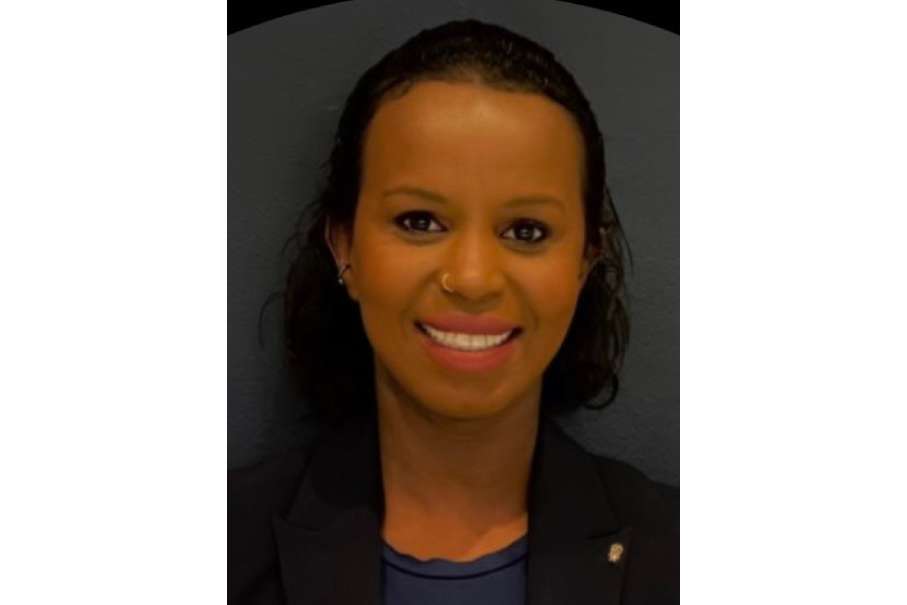 Woman smiles as she poses for a portrait.