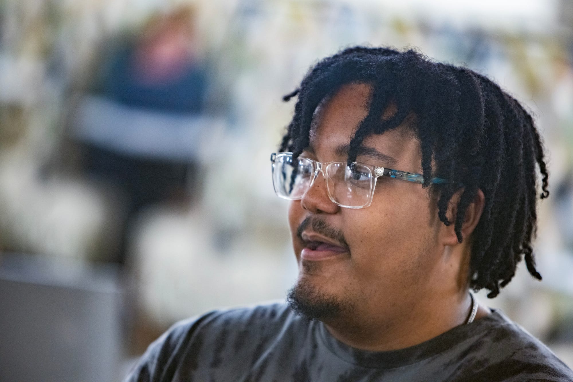 A young man with glasses speaks during a moderated conversation. 