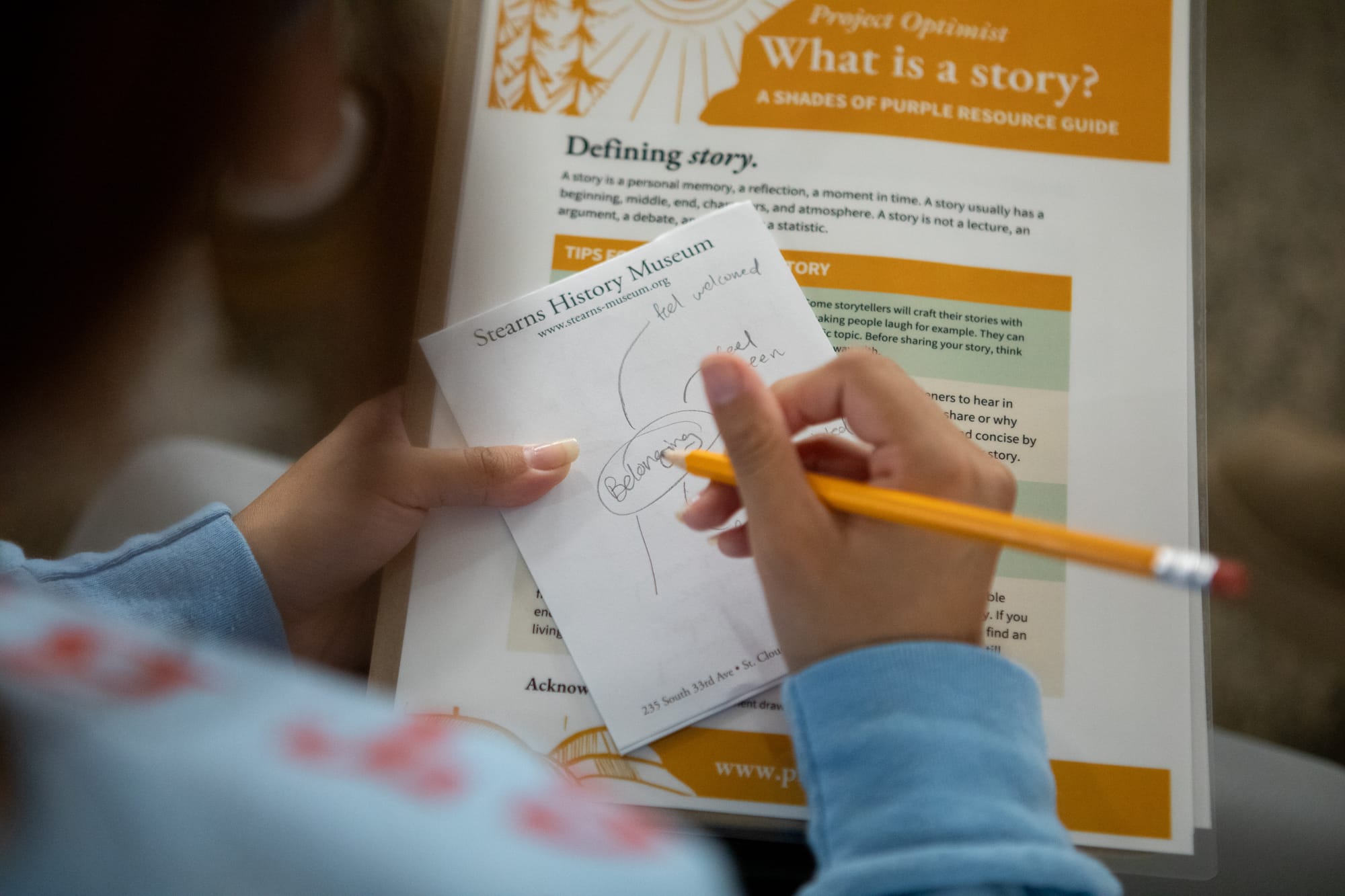  A close-up image of a young woman taking notes during an event. 