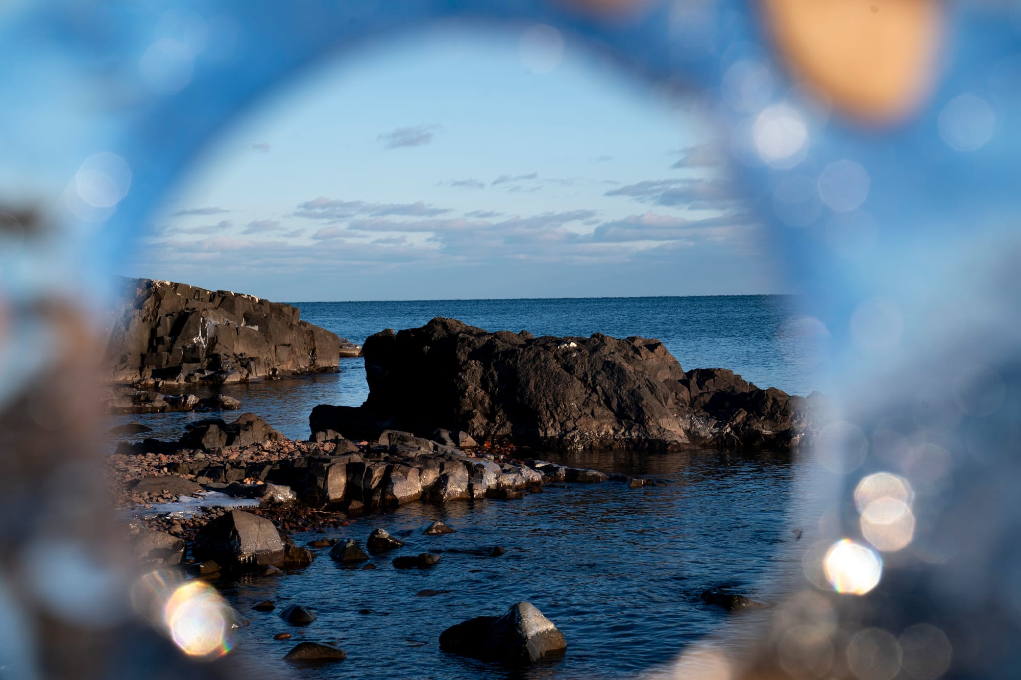 A view of the Lake Superior shoreline seen through a hole in a piece of ice in Duluth, Minn. 