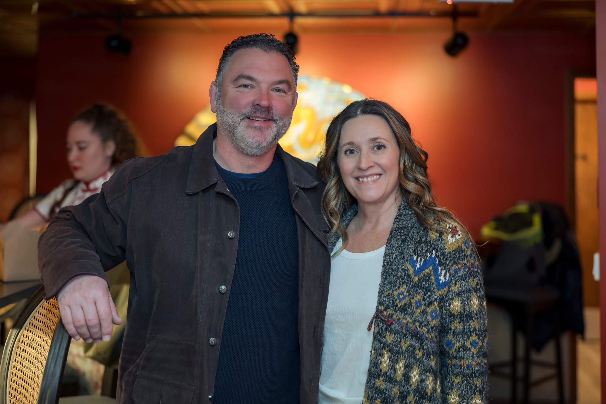 Man and woman smile for a photo in their brewery. 