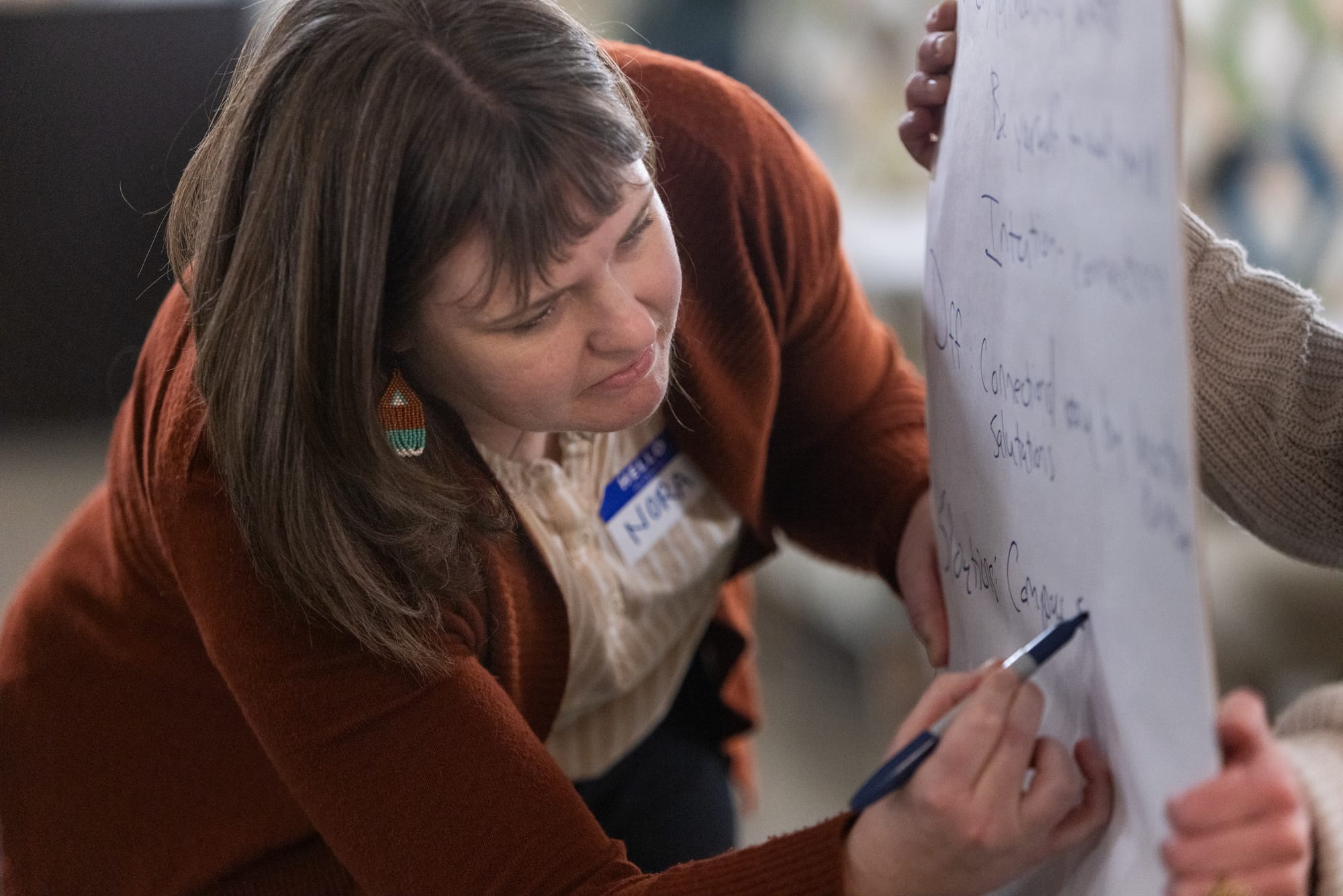 Woman writes with a marker on a giant notepad. 