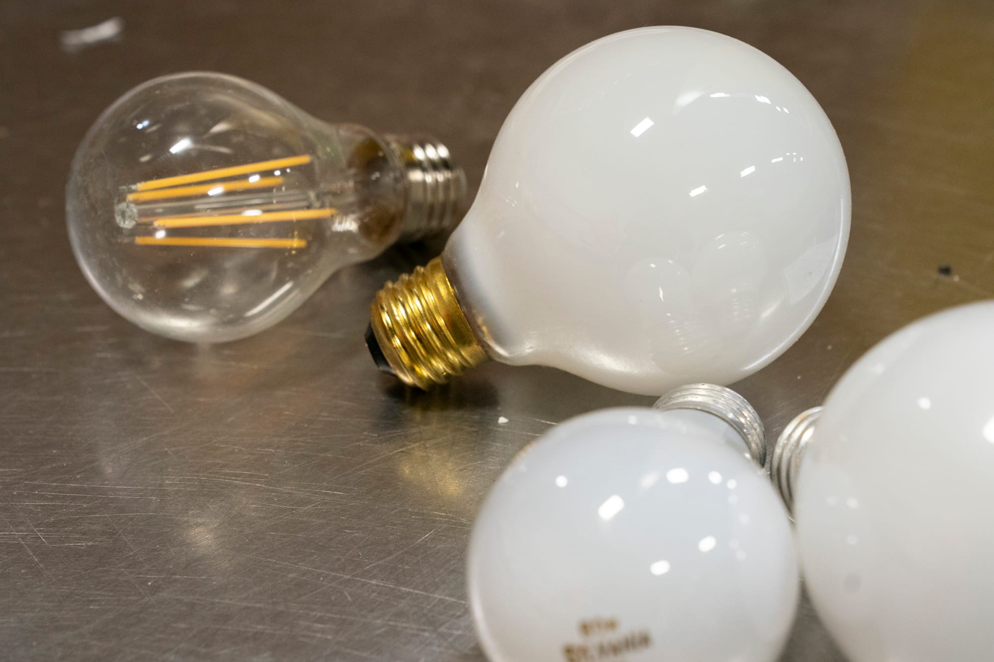 Light bulbs sit on a stainless steel table. 