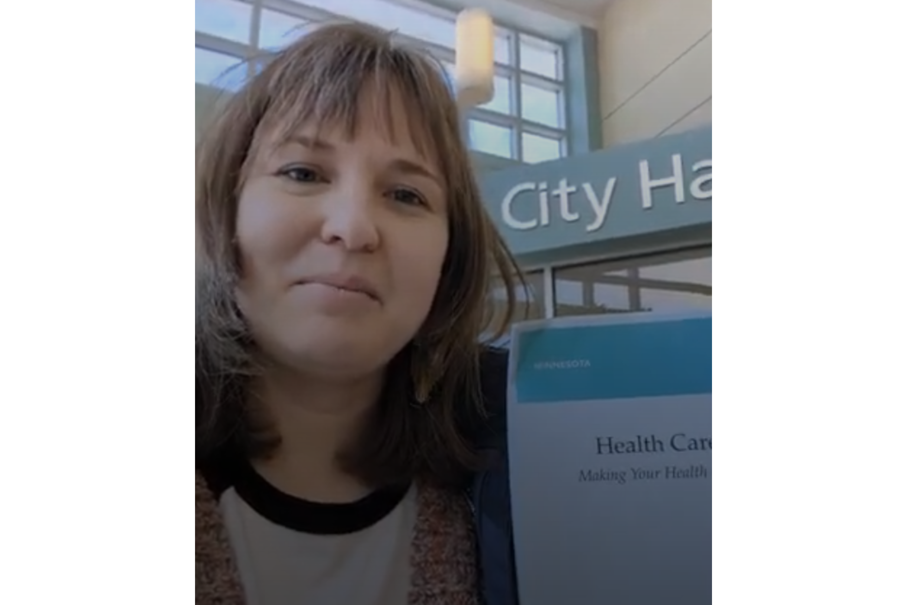 Woman with dark hair holds advance directive paperwork before getting it notarized at city hall. 