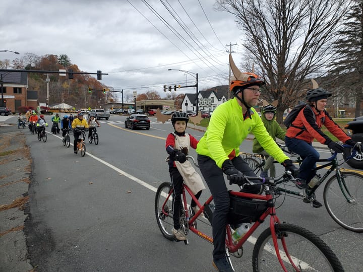 A group of people ride bikes in the fall. 