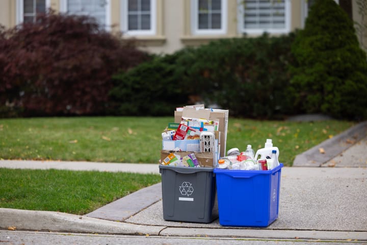 Recycling boxes sit on the curb outside a home in Canada waiting to be picked up. 